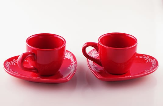 Red cups over plates, over white background