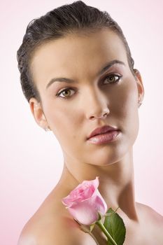 close up portrait of a pretty brunette with a pink rose
