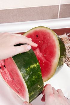 Cutting a slice of juicy water melon
