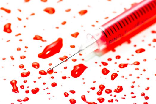 Hypodermic syringe with blood on a white background