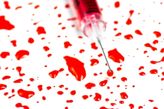 Closeup hypodermic syringe with blood on a white background