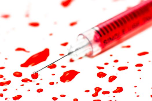 Closeup hypodermic syringe with blood on a white background
