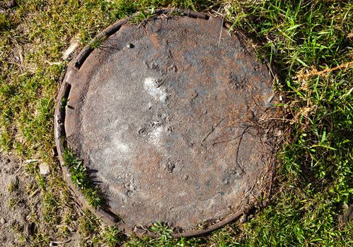 Manhole with rusty metal cover