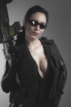 Brunette woman with enormous bulletproof vest and gun