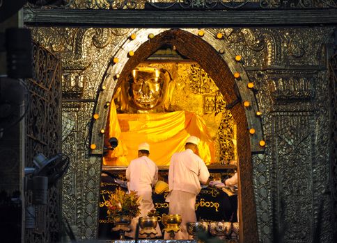 MANDALAY, MYANMAR - OCTOBER 9: The ritual of daily face washing Mahamuni Buddha at Mahamuni pagoda