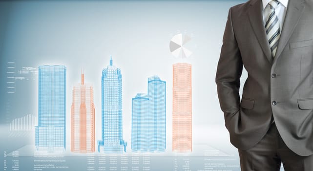 Businessman with high-tech skyscrapers and graphs