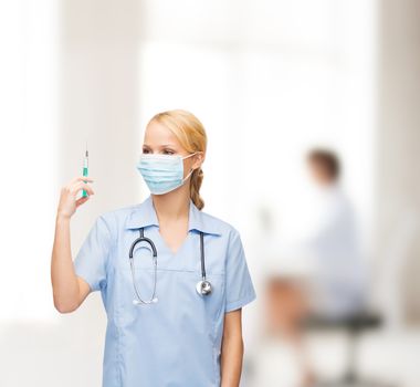 female doctor or nurse in mask holding syringe