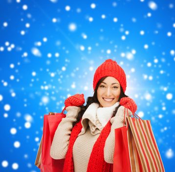 smiling woman in warm clothers with shopping bags