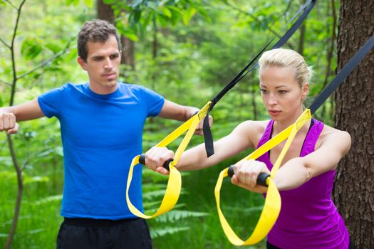 Training with fitness straps outdoors.