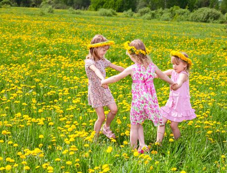 Children playing on a dandelion field
