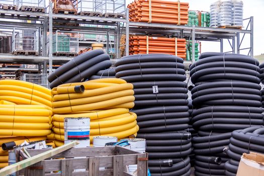 Rolls of plastic pipes in a warehouse yard