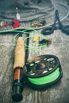 Fly fishing reel with old hat on bench 