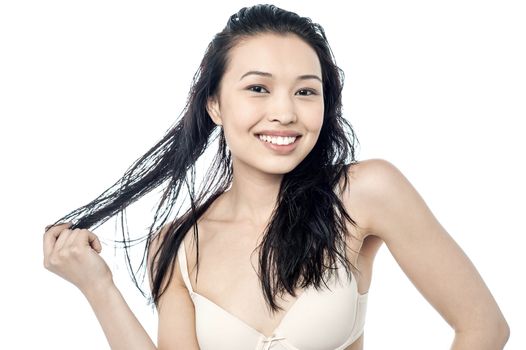 Smiling woman with healthy hair looks for split ends