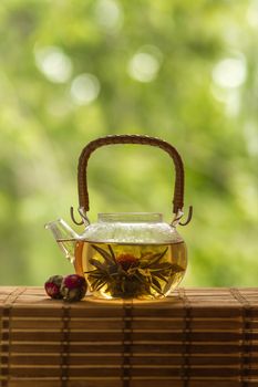 Transparent teapot with blooming tea flower 