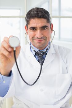 Confidence male doctor holding stethoscope