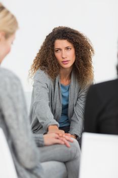 Concerned woman comforting another in rehab group at therapy