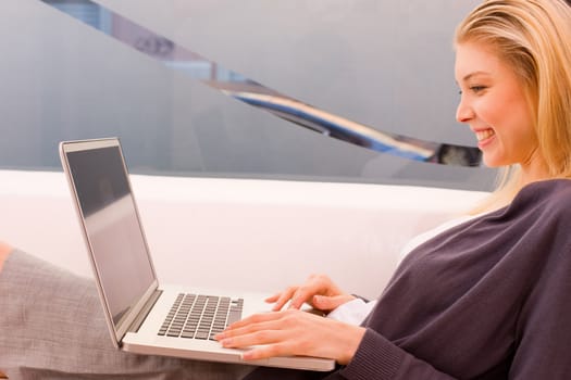 Smiling young woman using laptop