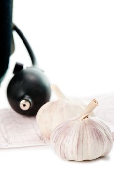 Sphygmomanometer, cardiogram and fresh garlic