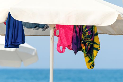 Sunshades and clothes on a sea beach  