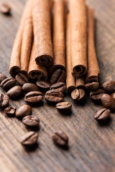 Coffee and cinnamon sticks on wooden background macro vertical