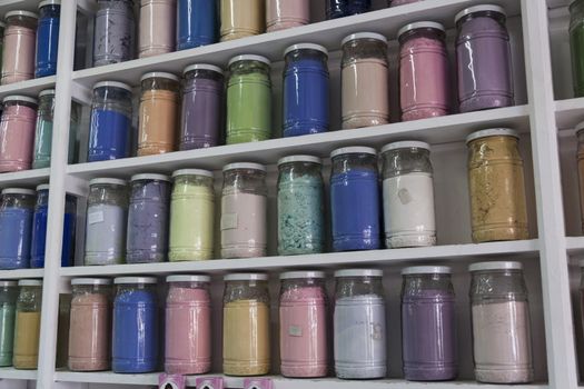 Shelving with glass jars of colorful pigments