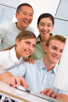Diverse group of happy people looking computer