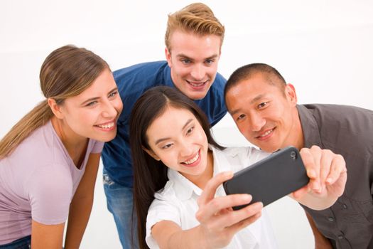 Happy multiethnic friends taking self portrait with cell phone