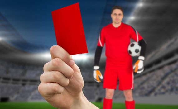 Composite image of hand holding up red card to goalie