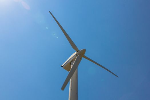 Wind turbine over the blue sky