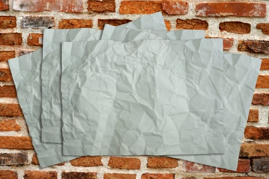 Wrinkled old paper on the brick.