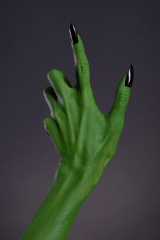 Green witch hand with black nails, real body-art 