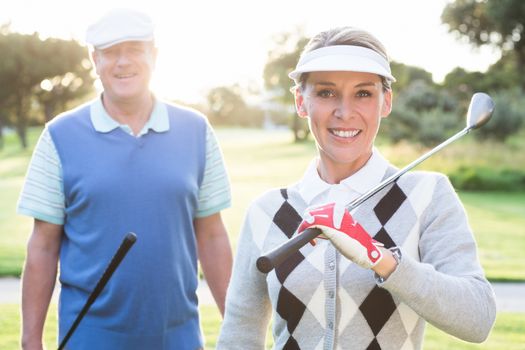 Golfing couple smiling at camera