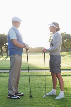 Golfing couple standing and talking