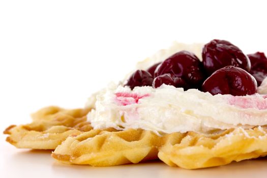 Close-up of waffle with whipped cream and cherries