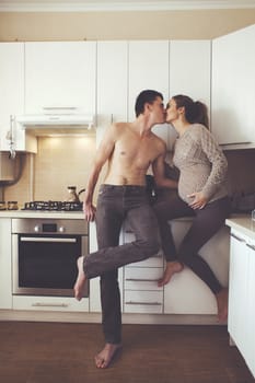 Romantic cozy home portrait of beautiful loving couple making coffee together at the kitchen at home