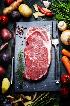 Food background with fresh vegetables and raw beef steak