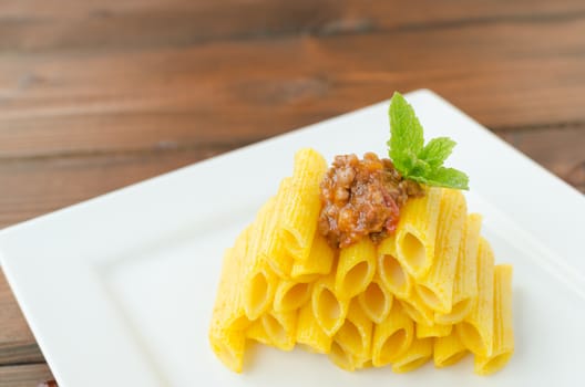 Penne Bolognese on wood table