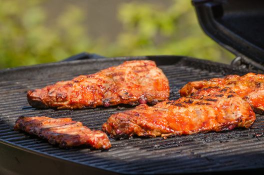 Spareribs on grill with hot marinade