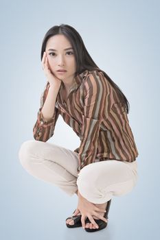 Squat pose by sexy Asian beauty