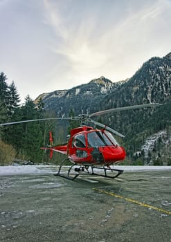 Red helicopter at mountain heliport at swiss alps