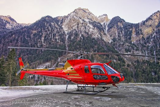 Red helicopter in heliport at swiss alps 