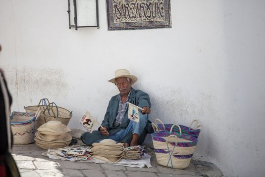 Elder street vendor selling handmade souvenirs