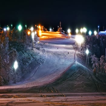 Snowboarders on the illuminated moumtain slope