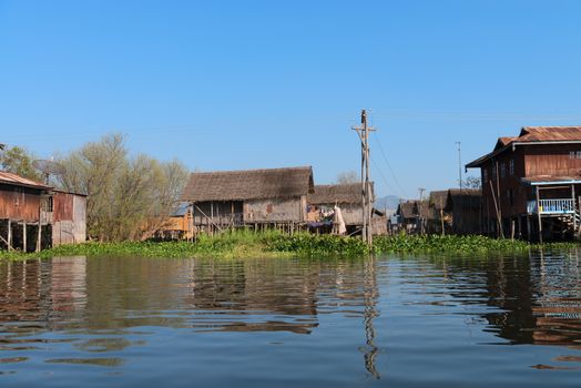 Traditional stilts house in water under blue sky