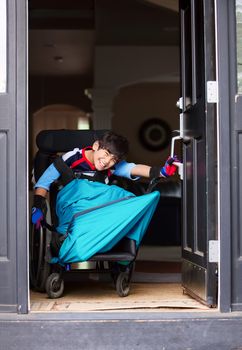 Disabled boy in wheelchair opening front door