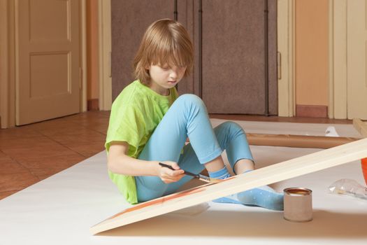 Boy with Blond Hair Painting a Board 