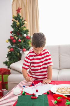 Cute boy drawing festive pictures 