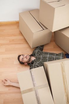 Man lying under fallen boxes