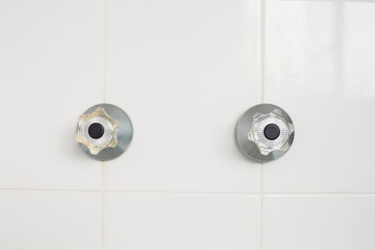 Taps on tiled wall