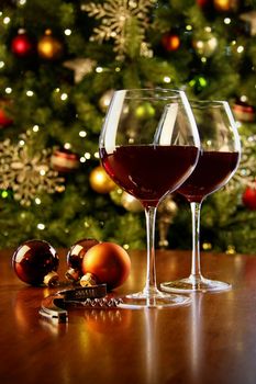 Glasses of red wine on table with Christmas tree